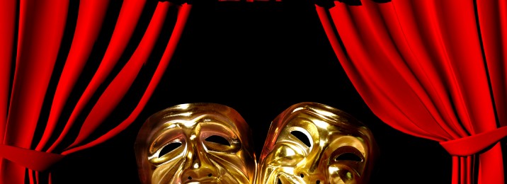 gold mask of tragedy and comedy between a red theatre curtain